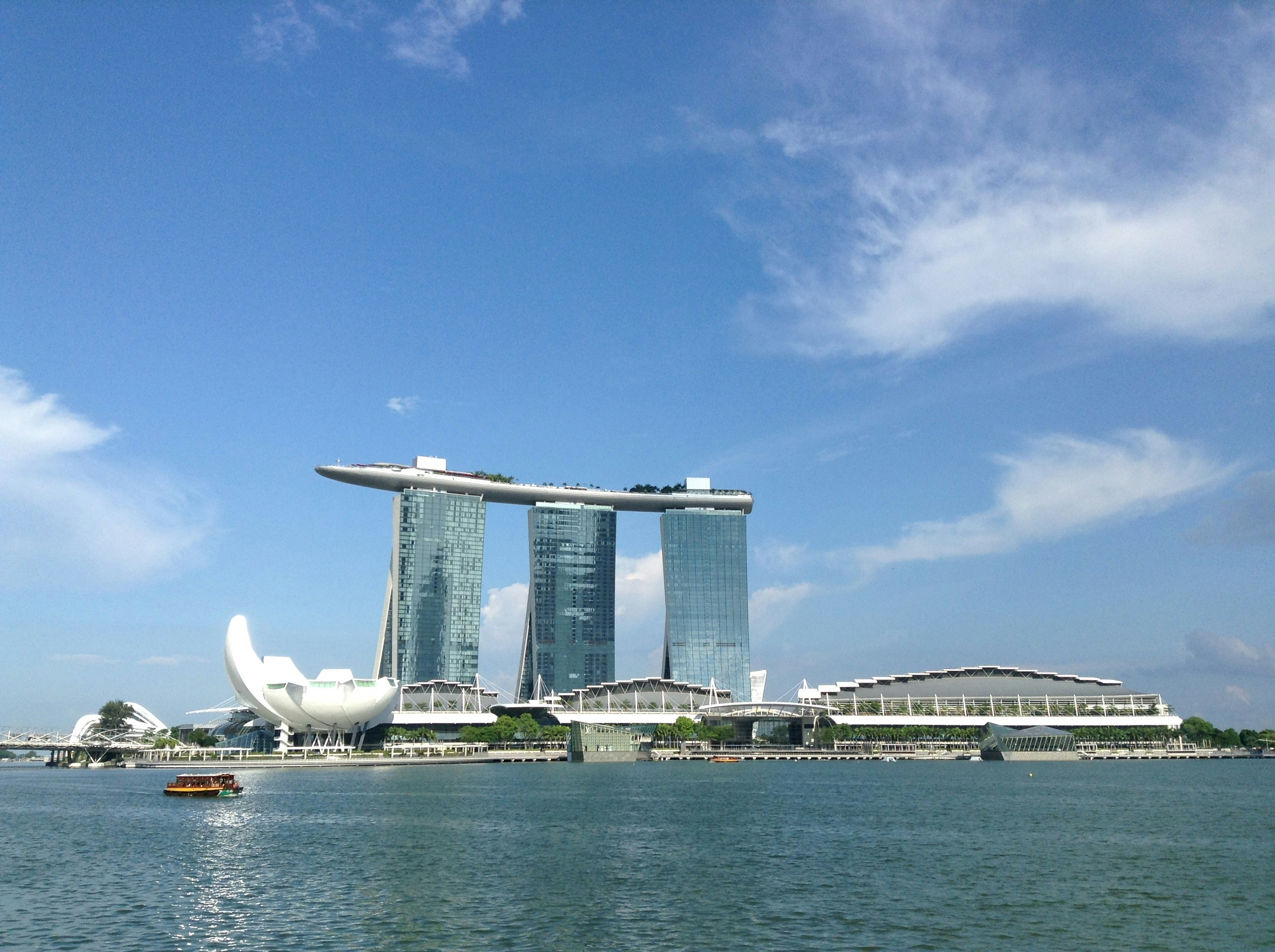 white boat on body of water near white concrete building during daytime